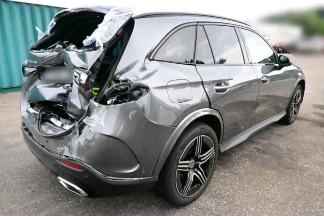Grauer SUV mit massivem Heckschaden nach Auffahrunfall, gesamte Fahrzeugansicht von schräg hinten.